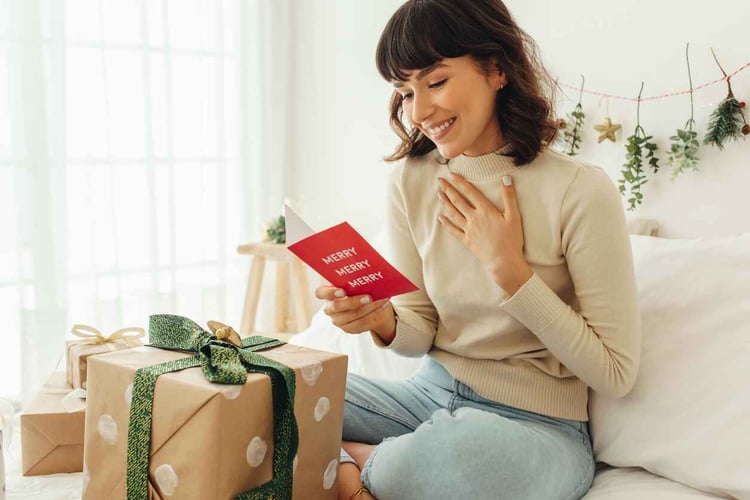 Young woman reads holiday greeting card